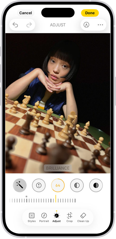 Muokkaa-näyttö, jonka keskellä on kuva. Näytön alareunassa vasemmalta oikealle lueteltuina ovat Tyylit-, Muotokuva-, Säädä-, Rajaa‑ ja Huolittele-painikkeet. Säädä-painike on valittuna ja näkyvissä on liukusäädin kuvan valoisuusasteen säätämiseen. Kumoa-painike on näytön vasemmassa yläkulmassa ja Valmis-painike oikeassa yläkulmassa.