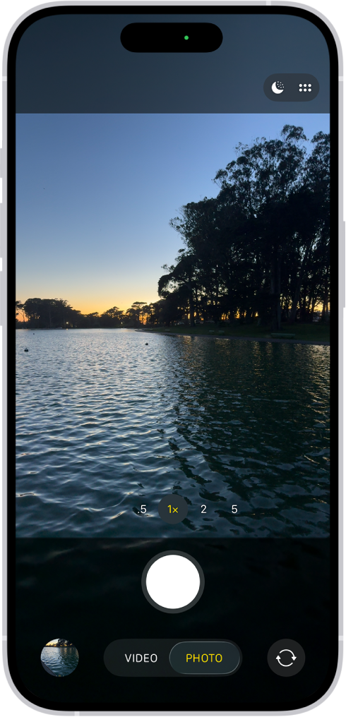 «Фото» режиміндегі «Камера» экраны. Көрініс тапқыш ішінде түн көрінісі. Түнгі режим және Камераны басқару элементтері режимі экранның жоғарғы оң жақ бұрышында пайда болады. Экранның төменгі жағындағылар солдан оңға қарай — «Фото және видео көру құралы» түймесі, «Видео және фото режимі» түймесі және «Камера таңдау - артқы камера» түймесі.