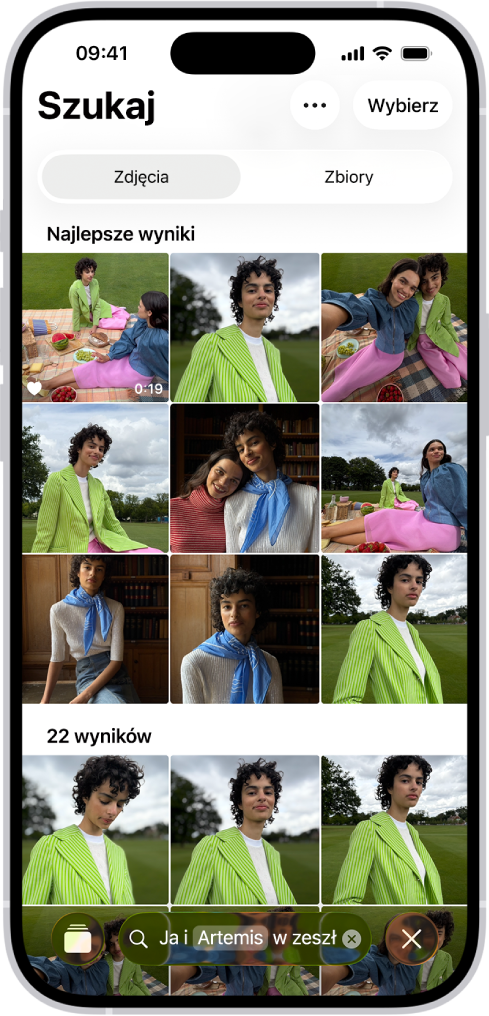 iPhone wyświetlający zdjęcia w aplikacji Zdjęcia. U dołu ekranu pojawi się pasek wyszukiwania z opisem.