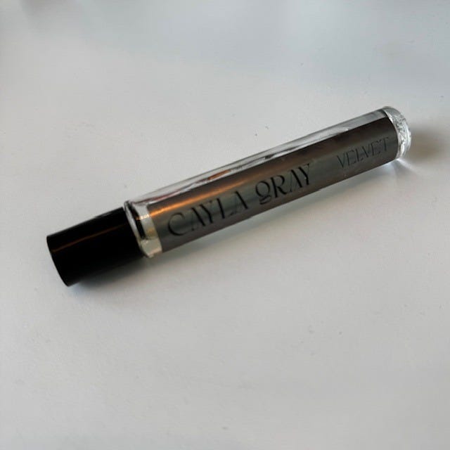 clear rollerball with a black cap containing a perfume oil labeled cayla gray velvet clear rollerball with a black cap containing a perfume oil labeled cayla gray velvet