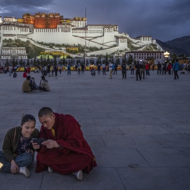 A Tibetan Buddhist monk and a woman share a mobile phone outside the Potala Palace in Lhasa, Tibet Autonomous Region, China, on June 1, 2021.