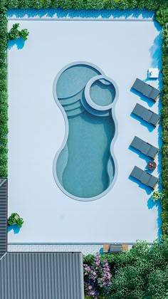 an aerial view of a swimming pool surrounded by greenery
