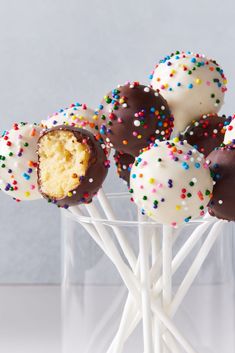 chocolate covered cake pops with sprinkles in a clear glass
