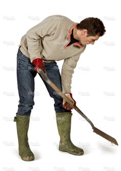 a man in boots and jeans holding a shovel