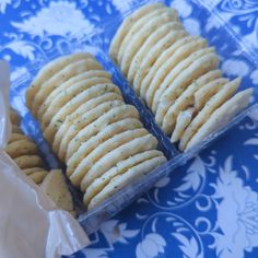 two plastic containers filled with crackers on top of a blue and white table cloth