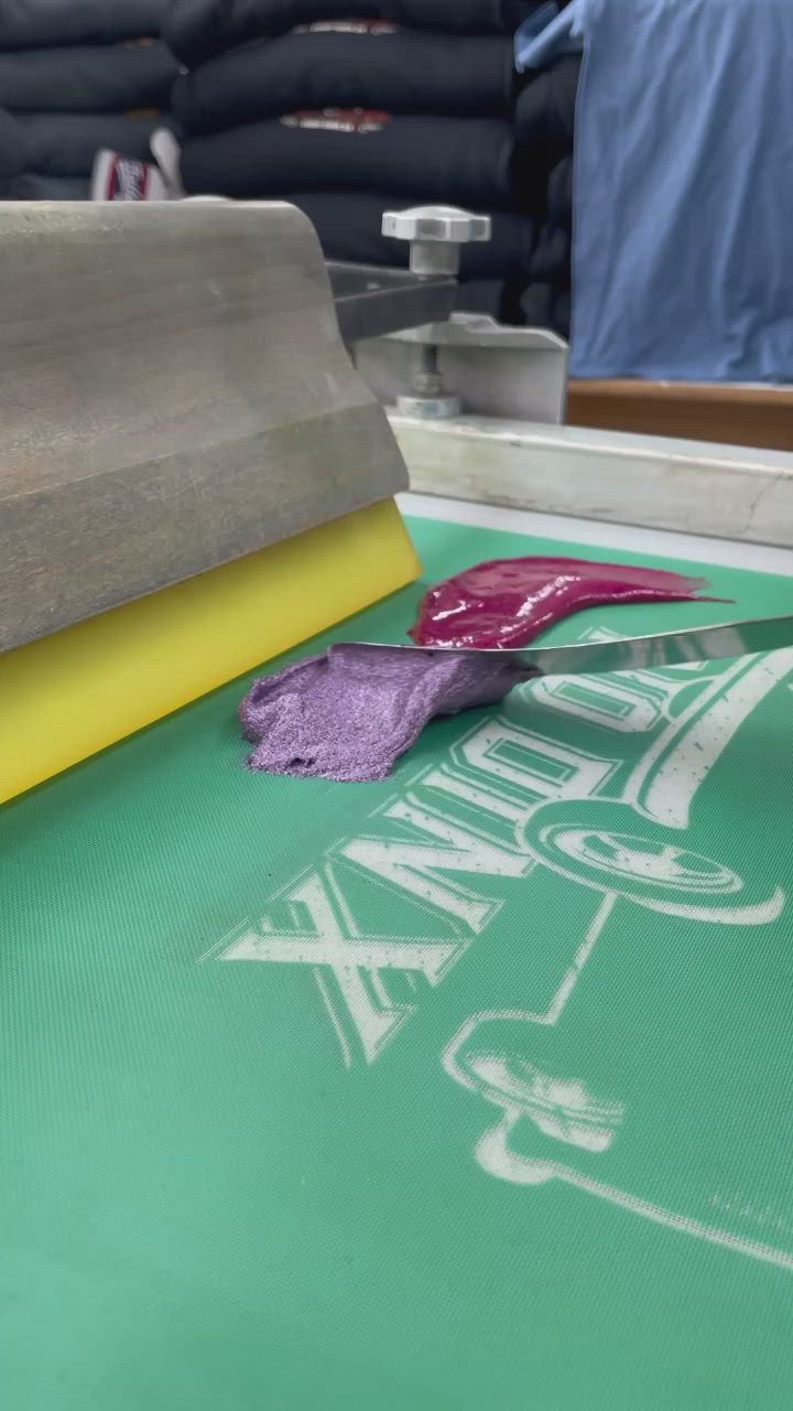 This may contain: a pair of purple slippers sitting on top of a green table next to a piece of paper