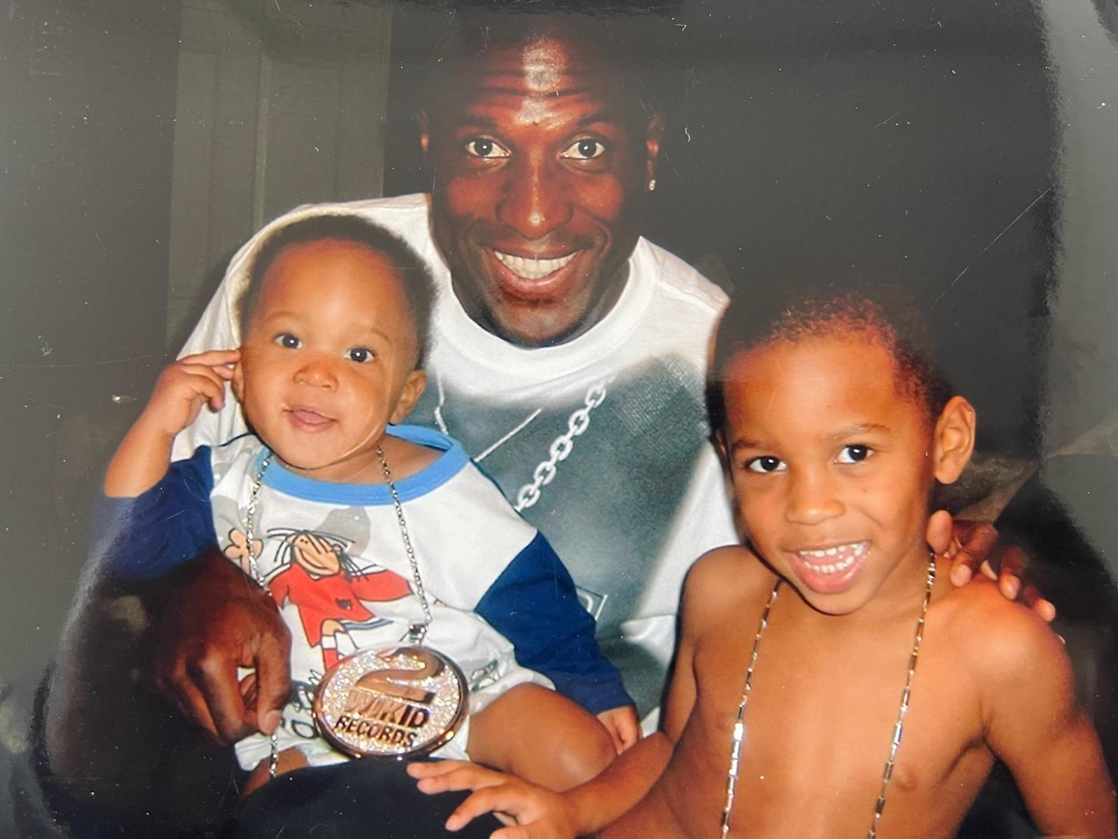 Kevin Campbell holds his sons Kyle and Tyrese while posing for a family photo in the early 2000s
