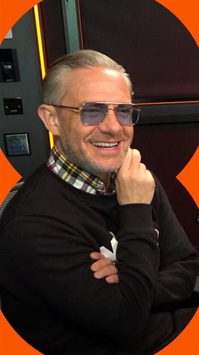 Martin Freeman wearing sunglasses, a checked shirt and a black jumper