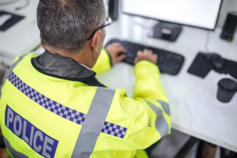 Police officer typing on keyboard