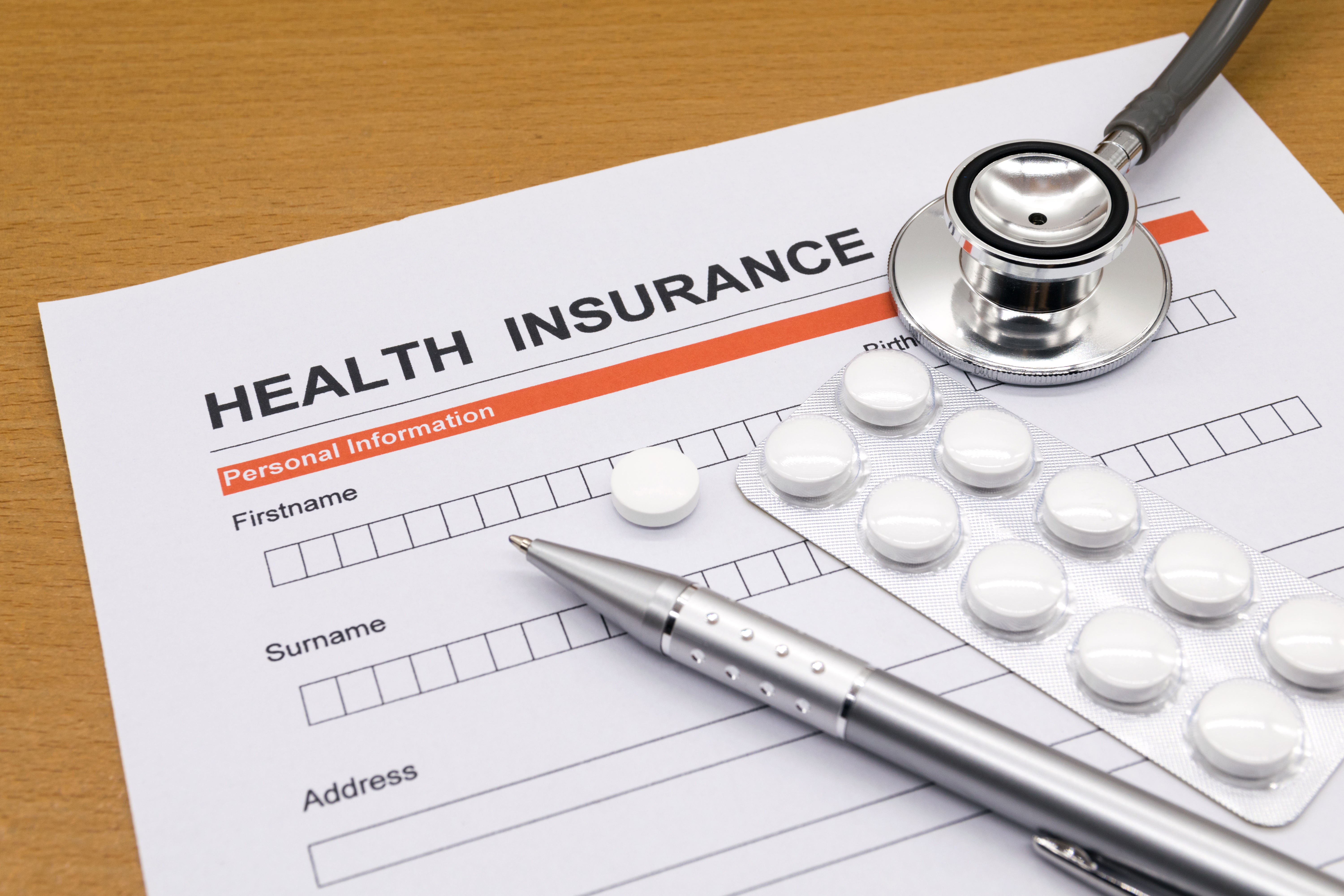 A health insurance application form with medication pills