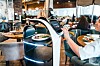 Robot waiter delivering a plate of food to a diner in a modern restaurant.