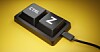 Close-up of two keyboard keys labeled Ctrl and Z on a yellow background with a cable attached.
