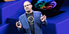 Cristiano Amon speaks onstage at a Qualcomm AI keynote, holding a device.