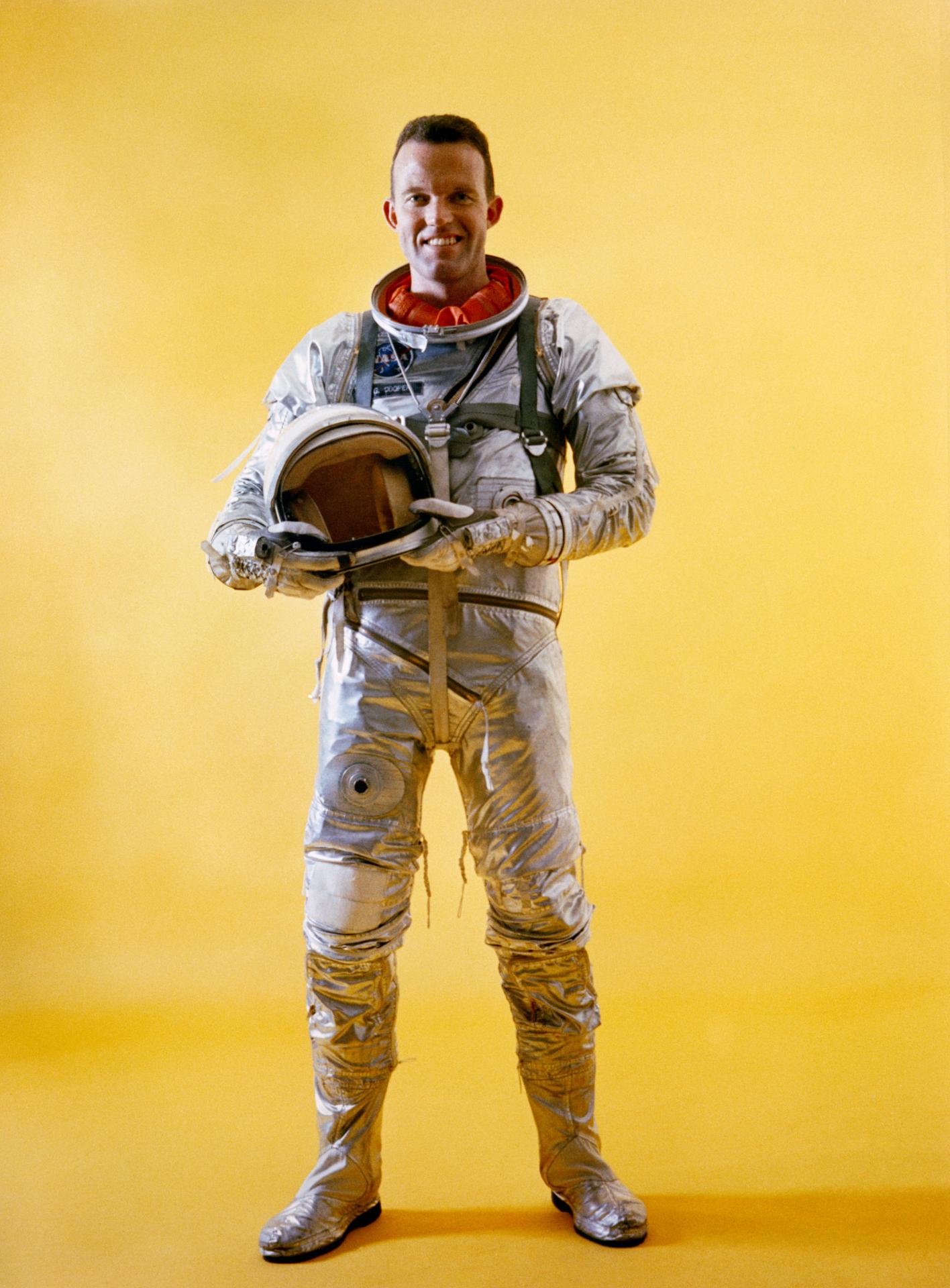Full-length portrait of Mercury astronaut L. Gordon Cooper Jr., in spacesuit during Mercury-Atlas 9 prelaunch activities, holding his helmet in his...