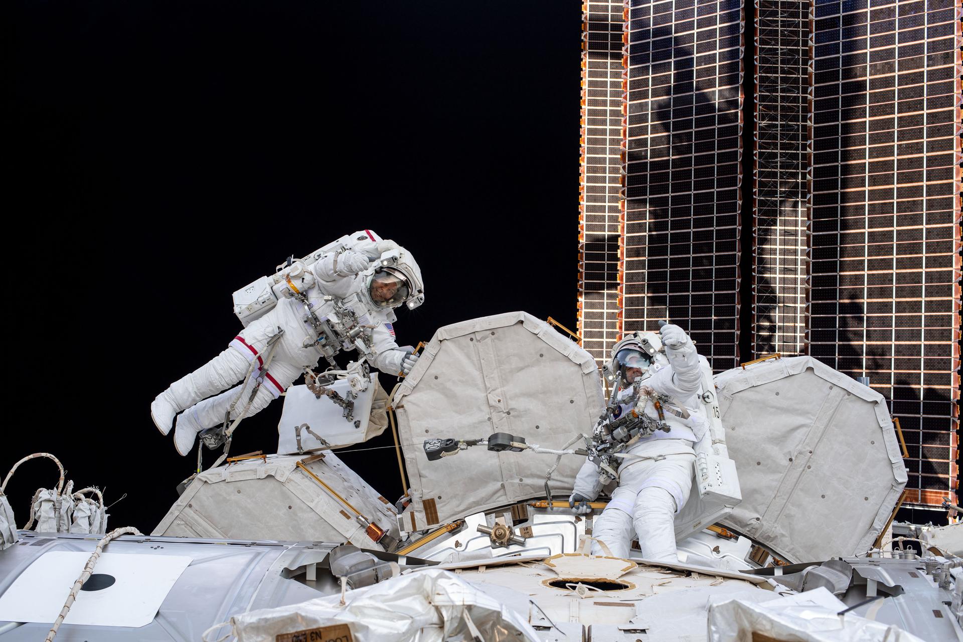 NASA spacewalkers (from left) Bob Behnken and Chris Cassidy give a thumbs up during a spacewalk to install hardware and upgrade International Space...