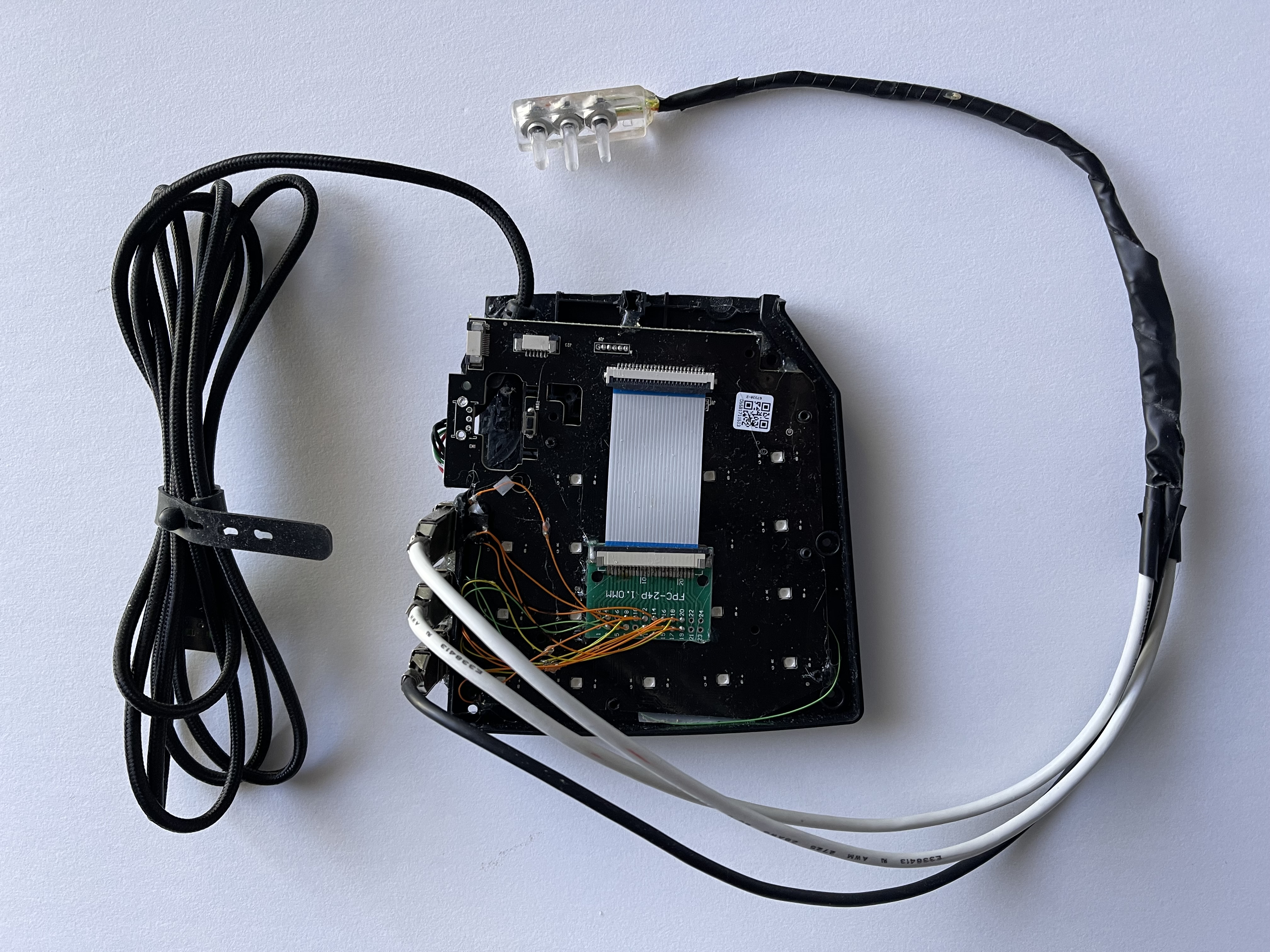 Chiou’s custom gaming hardware: an open plastic case with a ribbon cable connected to three USB ports with USB cables wrapped in electrical tape and connected to the microswitches.