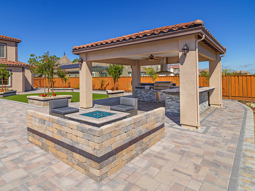 Pergola covered patio with outdoor kitchen and gas fire pit
