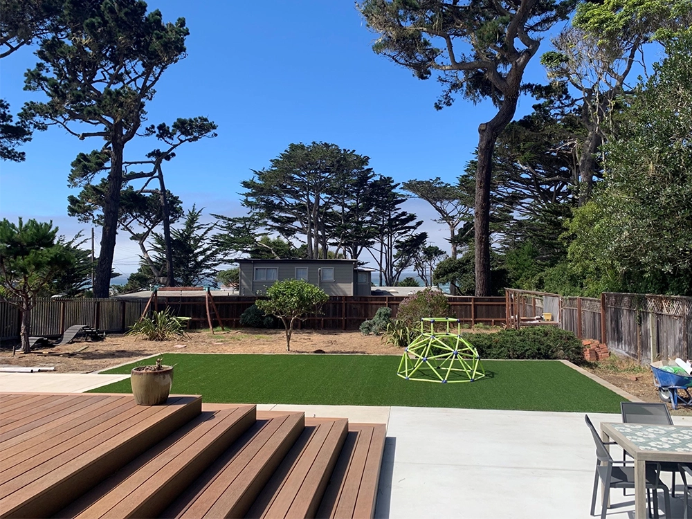 Beautiful artificial turf lawn in North Bay with a composite wood deck.