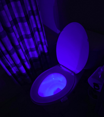 A reviewer image of a toilet shining blue in a dark room