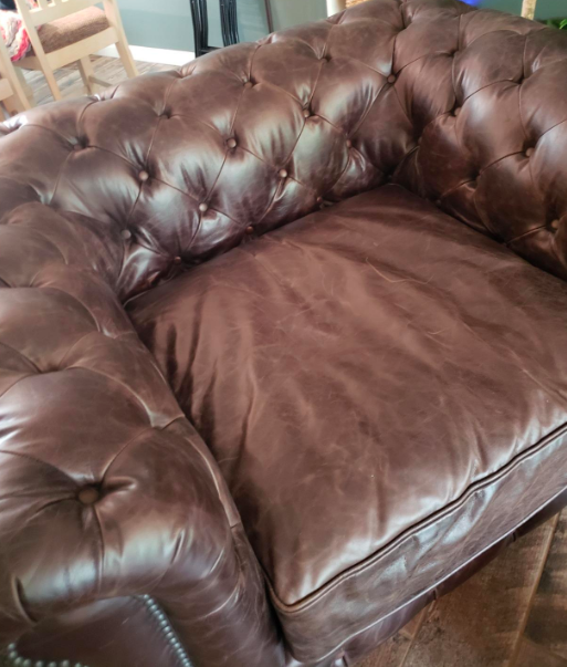 reviewer before image of a dull brown leather armchair