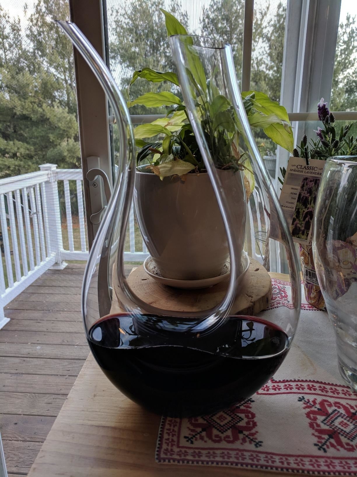reviewer image of the u-shaped glass decanter with one side thicker than the other and wine at the bottom of it