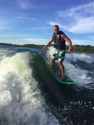 Reviewer boarding on a lake with a clear wave formed from the back of the boat