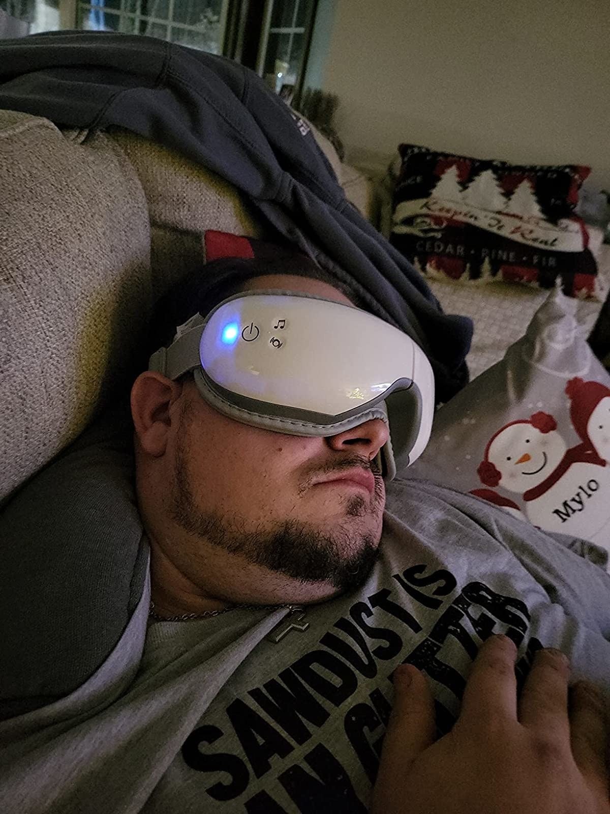 Reviewer falling asleep on couch with heated eye massager on face