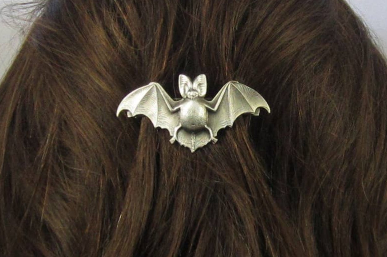 A silver bat-shaped hair clip is securing dark hair, showcasing its detailed wings and body