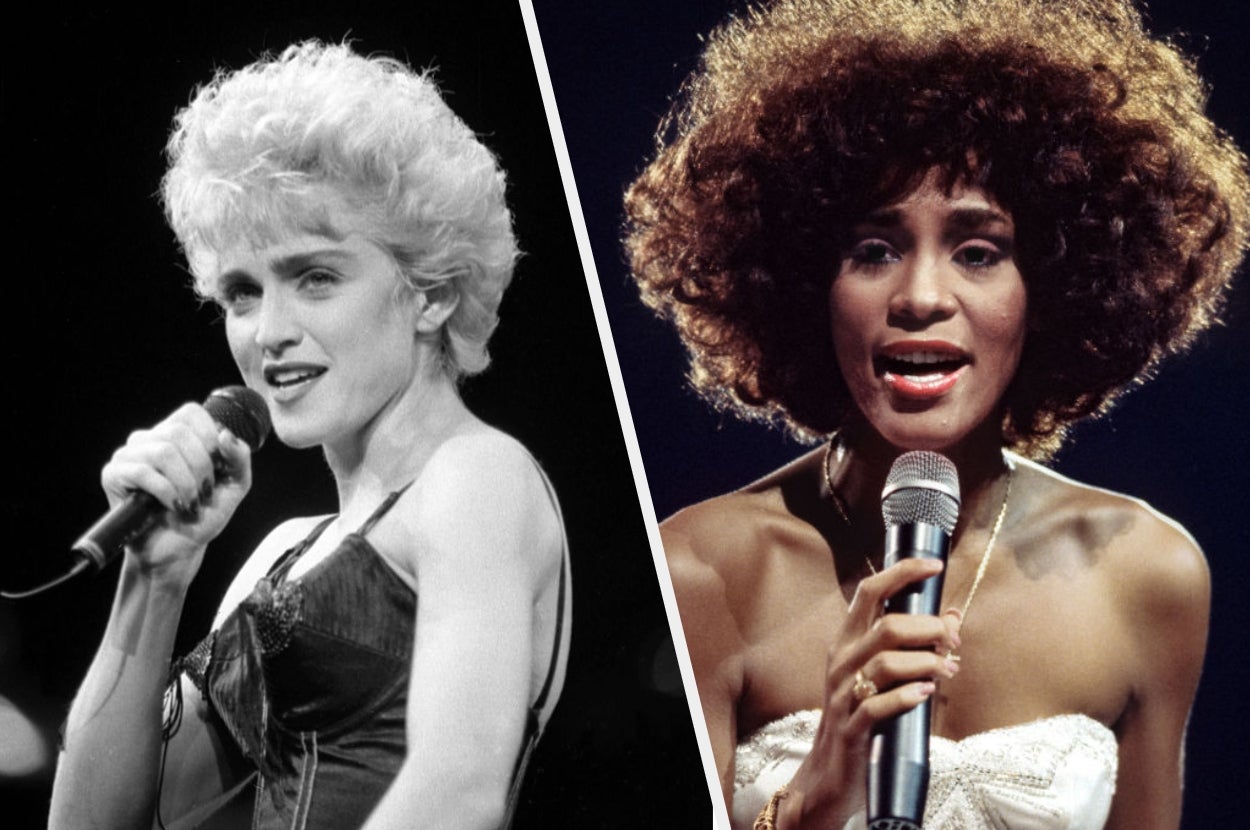 Two women performing on stage, one in a vintage-style top and the other in a strapless dress, each holding a microphone