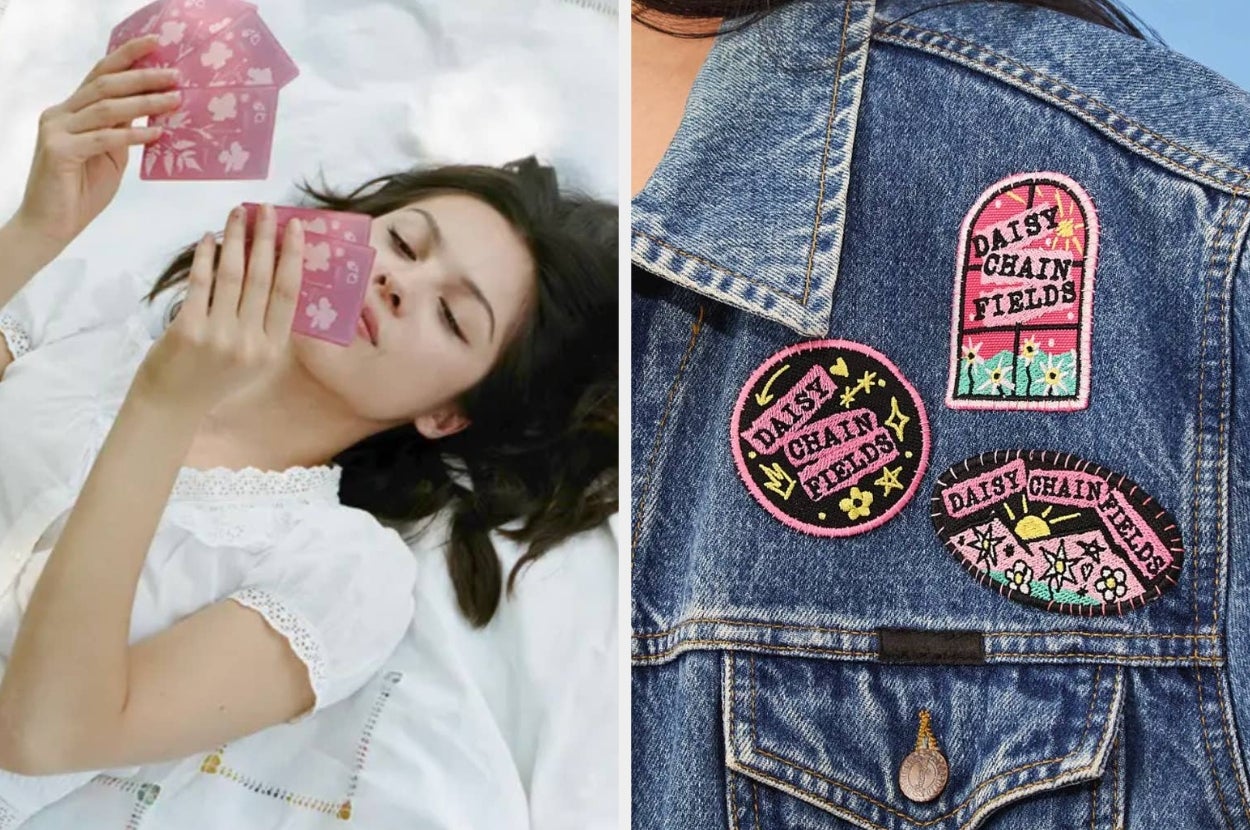 Person reading card in bed; denim jacket with floral patches labeled "Daisy Chain Fields."