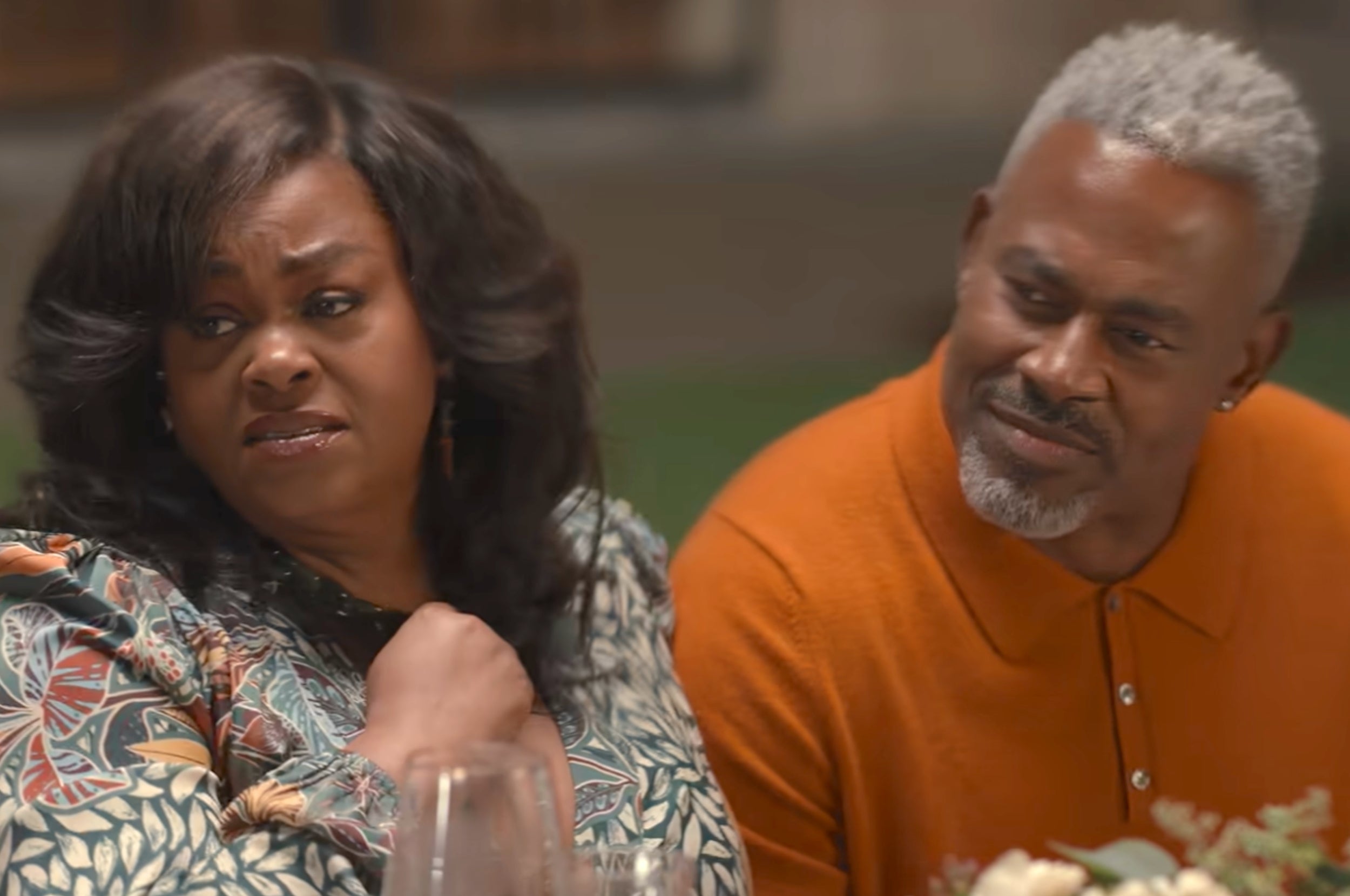 Jill Scott and Lamman Rucker sitting at a table next to each other, appearing engaged in a conversaiton as Sheila and Troy in Why Did I Get Married Again