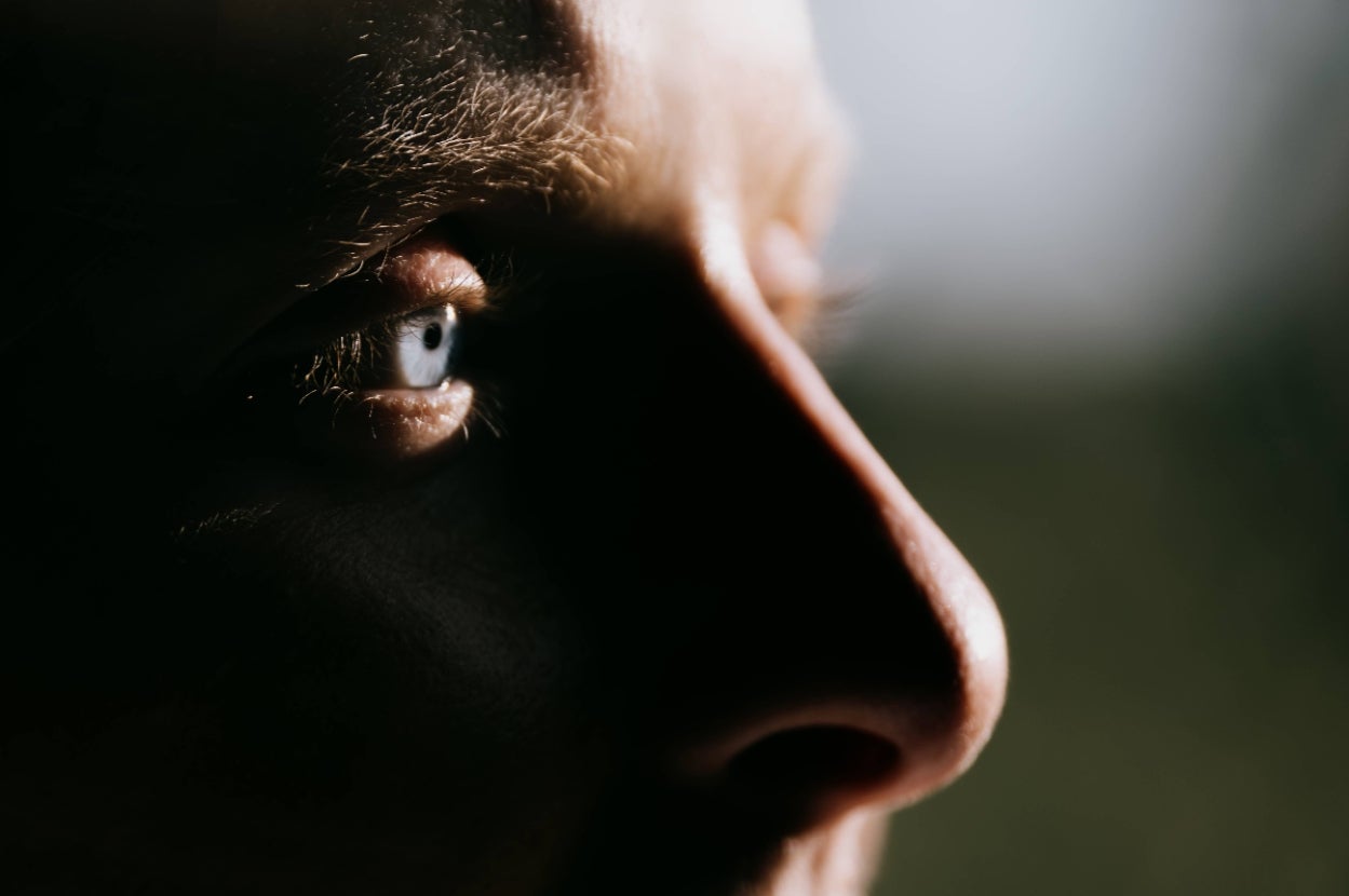 Close-up of a person looking intently, capturing the side of their face and eye, suggesting focus or contemplation related to health