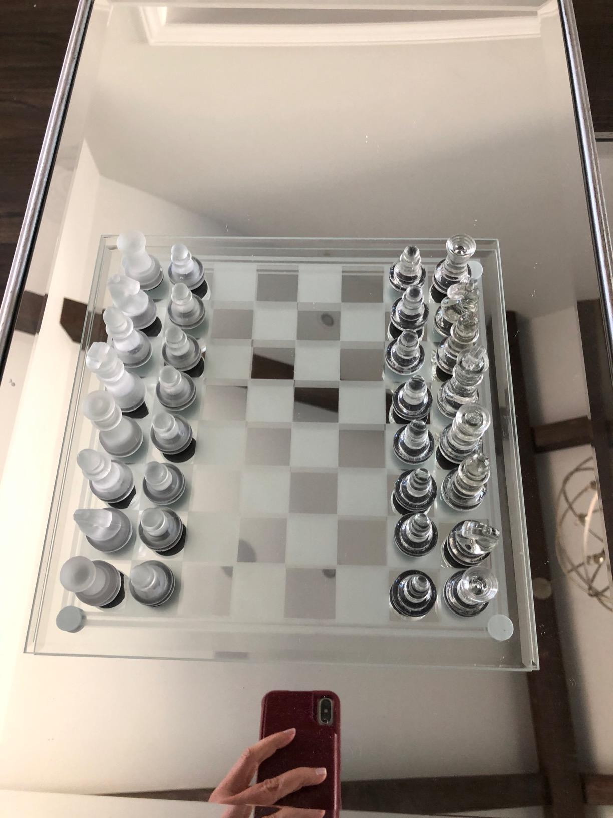Glass chess set on a mirrored board
