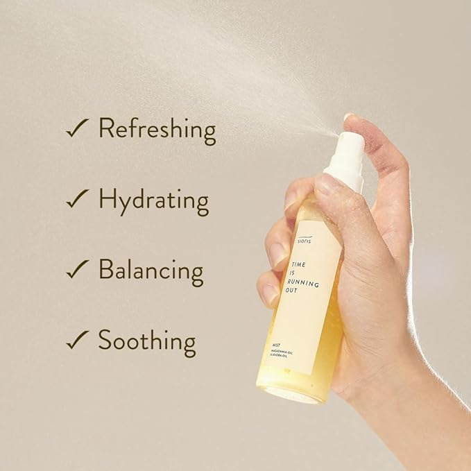 Hand holding a spray bottle labeled 