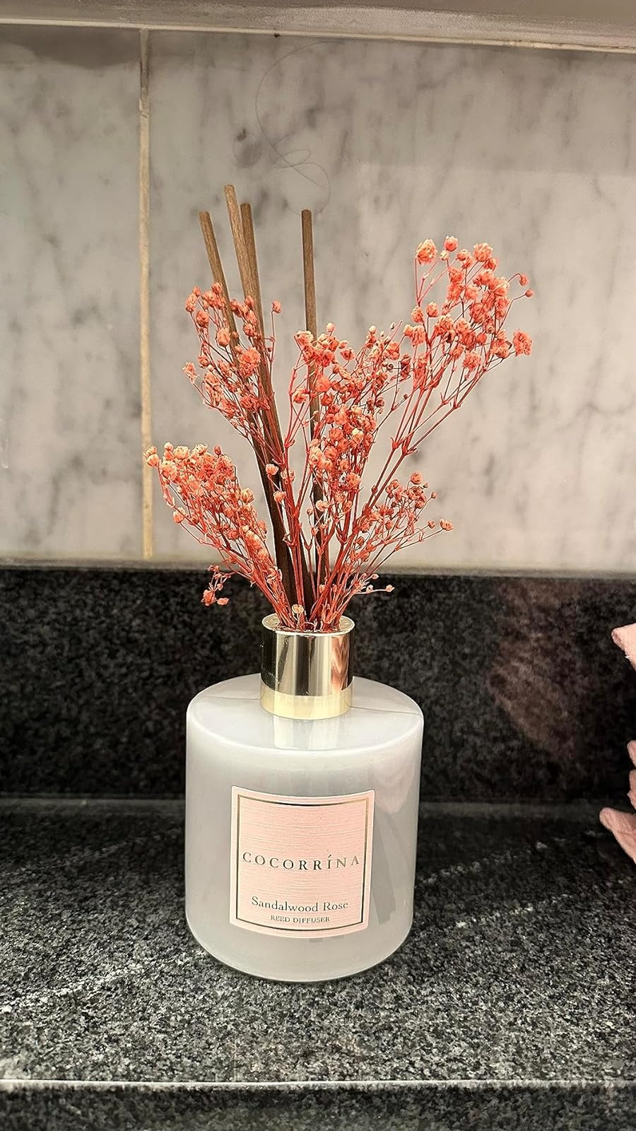 reviewer's iffuser with orange blossoms on a marble surface