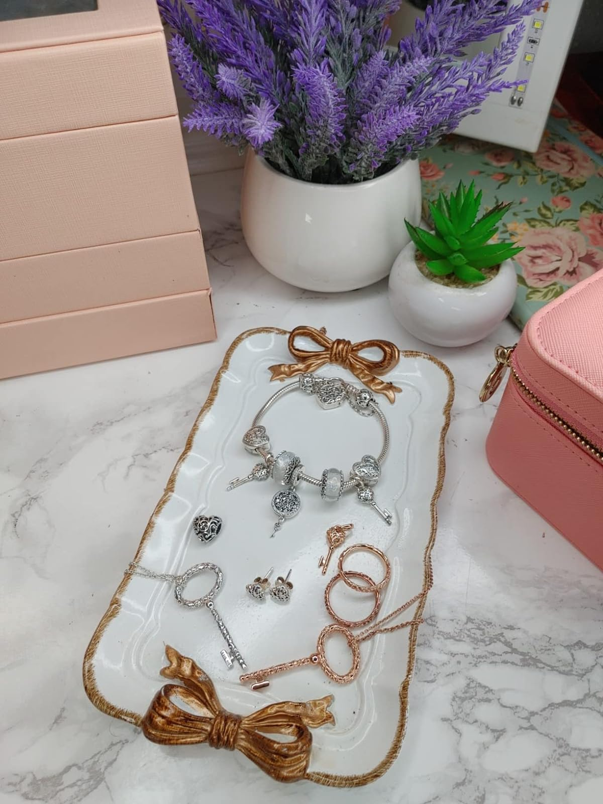 white rectangular vintage-style catch all with gold trim and gold bows on both ends