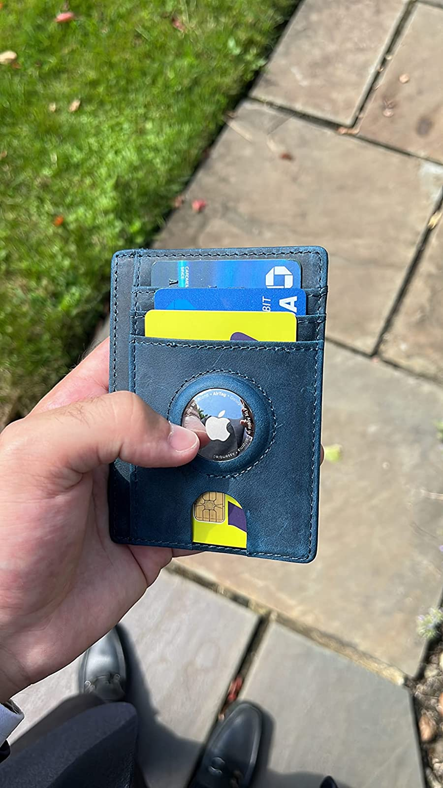 Reviewer holding their wallet with their AirTag attached to the wallet