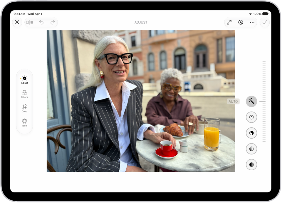 Pantalla de edición en la app Fotos con una foto en el centro. A la izquierda de la foto están los botones Estilo, Ajustar, Recortar y Limpiar; Ajustar está seleccionado. A la derecha de la foto están los botones de los efectos de edición y un regulador para ajustar el nivel del efecto.