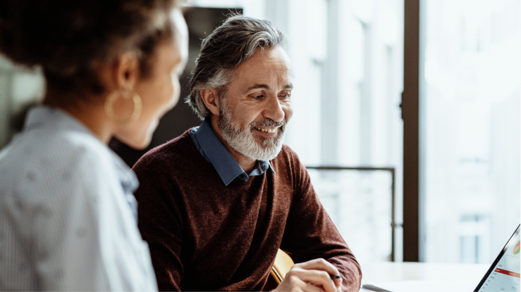 Dos personas con un portátil cerca de una ventana