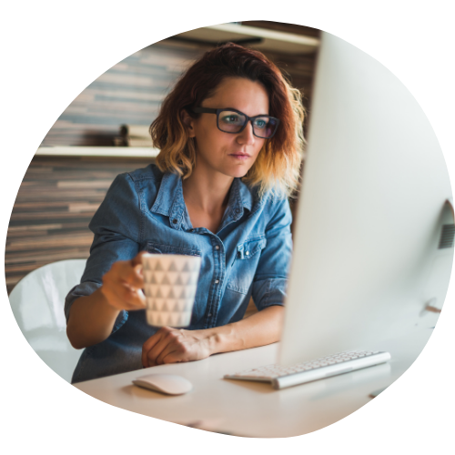 Woman at computer Woman with coffee at computer