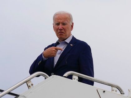 President Joe Biden motions before boarding Air Force One at Kirtland Air Force Base after
