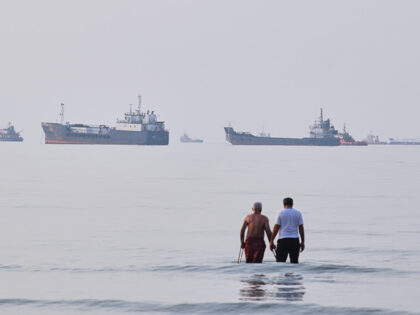Title: Iran War Strait of Hormuz Image ID: 26194339749499 Article: Two men wade in the wat