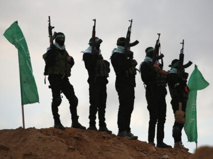 TOPSHOT - Palestinian Hamas militants gather at the site of the handing over of the bodies