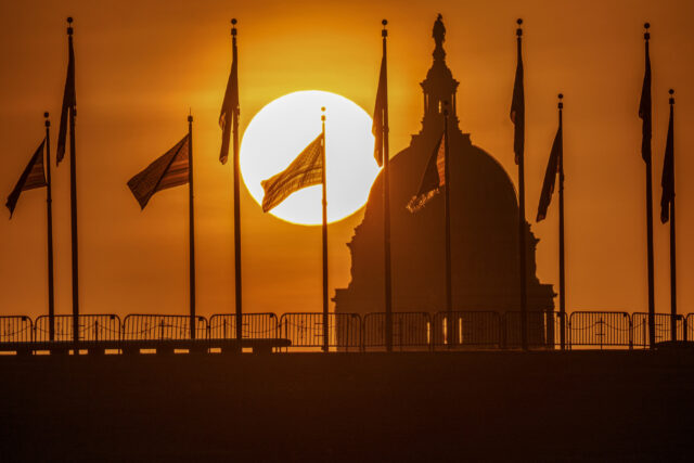 U.S. Capitol Building Sunrise WASHINGTON, DC - SEPTEMBER 16: The U.S. flag is silhouetted in the rising sun with the U.S