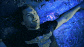 a man wearing a harley davidson shirt is laying in a pool of water