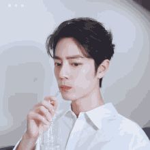 a man in a white shirt is drinking from a plastic bottle