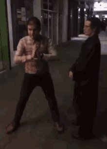 a man in a plaid shirt is walking down the street