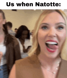 a woman is sticking her tongue out and smiling while standing in a crowd .