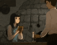 a man and a woman are standing next to each other with a candle in the background