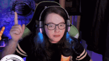 a woman wearing glasses and headphones is sitting in front of a microphone